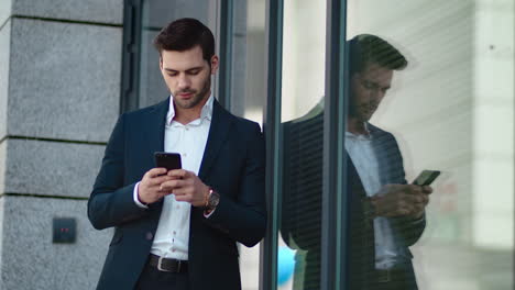 closeup man standing with phone outside. businessman using smartphone at street