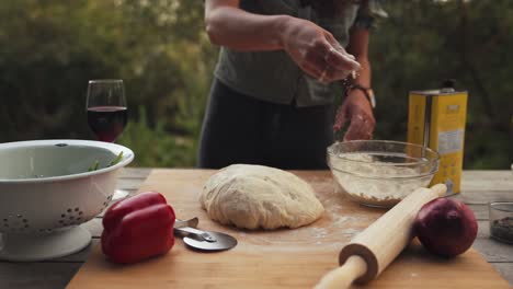 slow motion shot of dough being prepared outside to make a homemade pizza