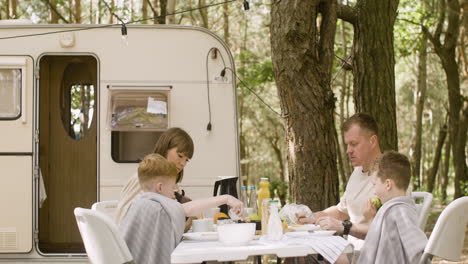 happy family having breakfast at the camping in the forest