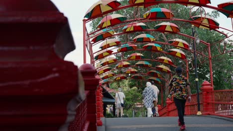 colorful umbrella walkway over a red bridge in langkawi, malaysia, vibrant atmosphere