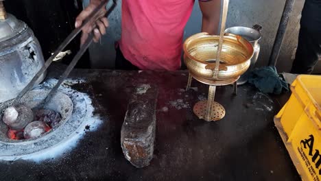 the shopkeeper is taking out the kulhad cup from the hot tandoor for tandoori tea - tandoori kulhad chai