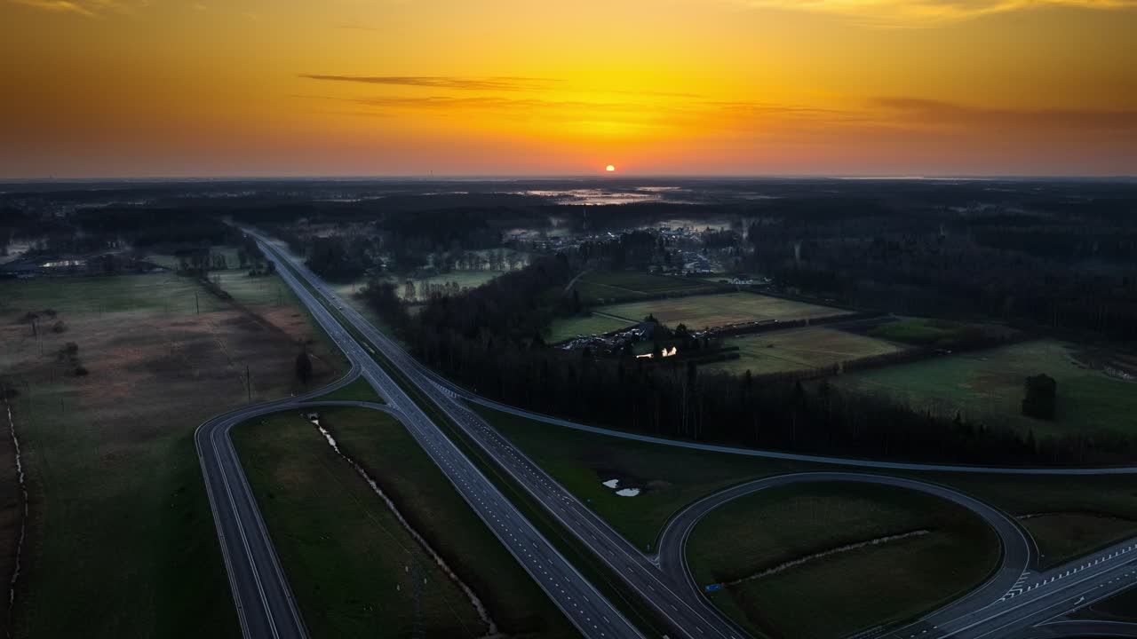 Cinematic sunrise over green fields and roads near Riga moving aerial hyperlapse
