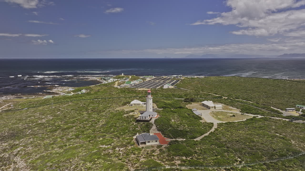 Gansbaai South Africa Aerial v15 flyover Birkenhead capturing the Danger Point Lighthouse standing on the green terrain and the scenic coastal landscape - Shot with Mavic 3 Pro Cine - Jan 8th 2024