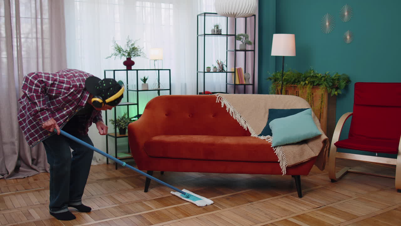 시니어 할아버지는 집에서 빛나는 아파트 거실에서 바닥을 고, 음악을 듣고, 춤을 추고 있습니다.