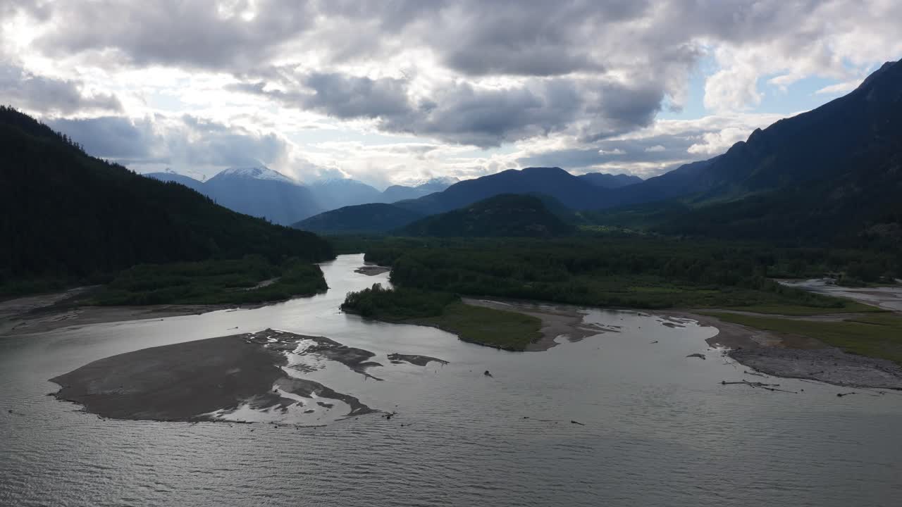 Scenic river delta view with mountains and clouds at sunset near Bella Coola, BC, Canada.