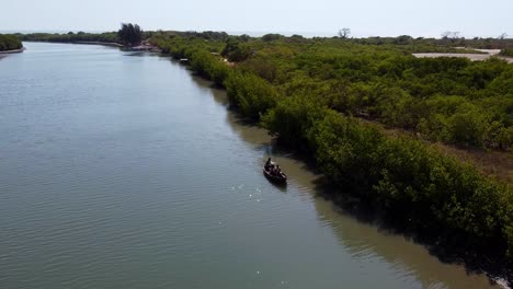 Aerial-view-of-local-tourists-taking-a-canoe-ride-on-River-Gambia-shot-at-Stala-Adventures,-Kartong---The-Gambia