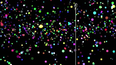 retro metallic microphone against colorful spots of light against black background