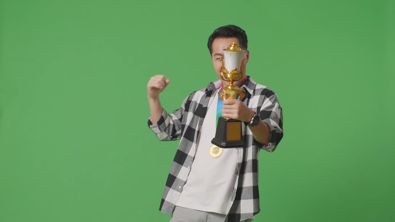 트로피와 메달을 들고 있는 행복한 우승자