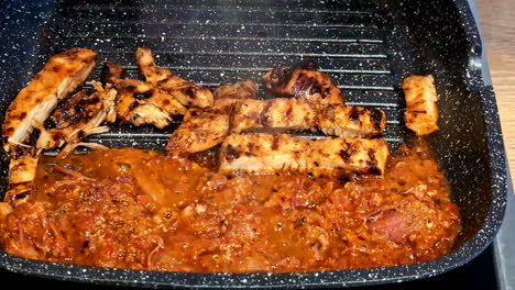 chicken meat grilling with sauce in grill pan. closeup shot