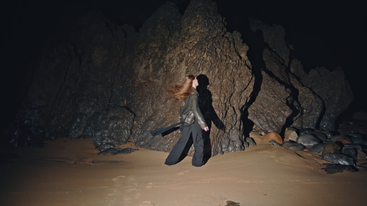 밤에 모래 해변을 는 긴 머리 모델. 여성 댄스 페스티벌