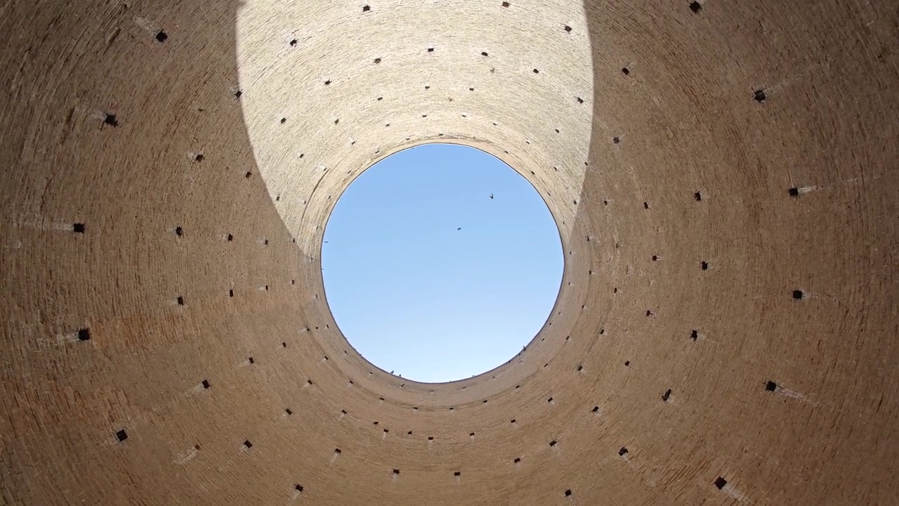 鳥が飛び交う古代のレンガ造りの塔の内部をローアングルで見る