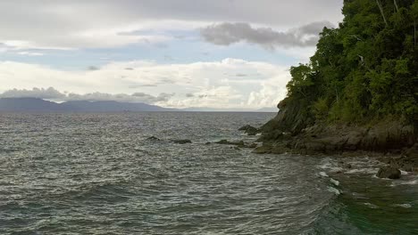 scenic coastline of looc beach surigao aerial dolly as tranquil ocean waves crash on coast