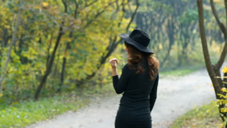fashion woman walking in autumn park. outdoor fashion video of young beautiful lady surrounded autumn leaves