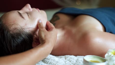 Pretty-brunette-receiving-face-massage-with-oil-at-home