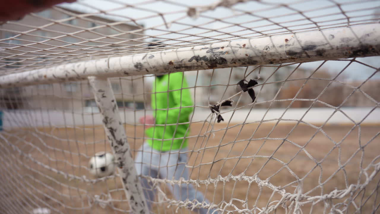 closeup of athlete striking net effectively, intimate shot capturing player successfully sending ball into goal, detailed view of athlete making precise shot to score in soccer match