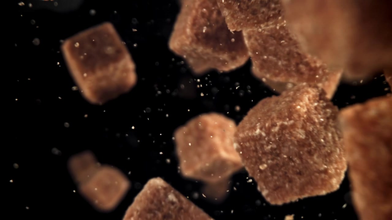 Brown Sugar Cubes Falling in Slow Motion Against Black Background