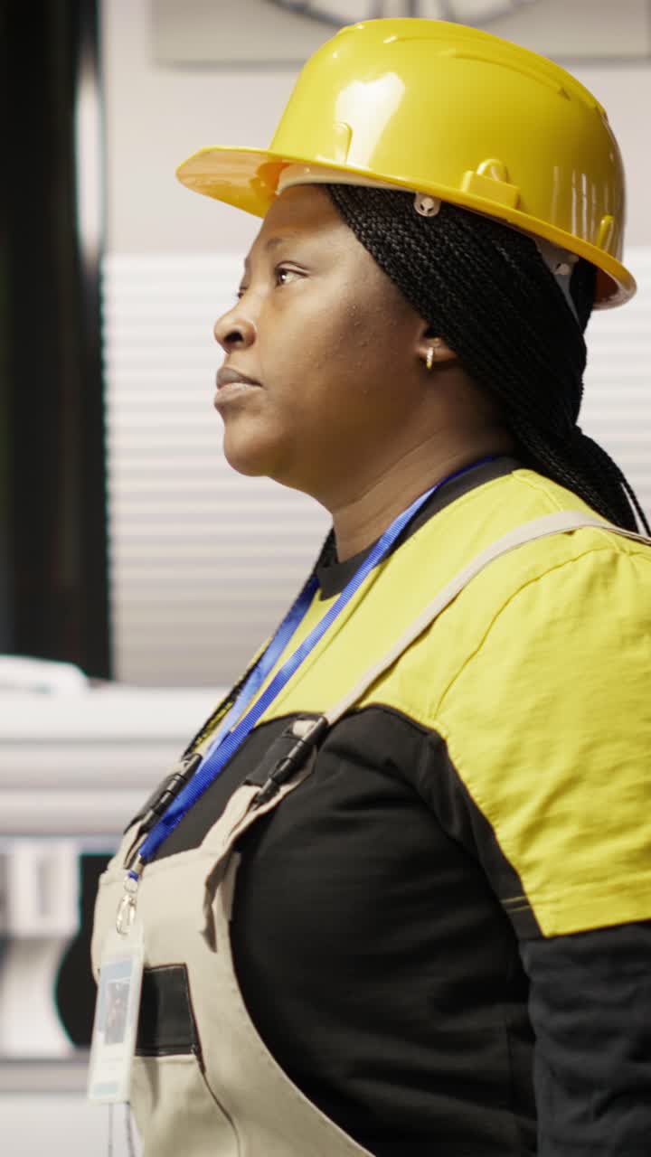 Vertical video Technician walking in industrial plant, using toolbox to fix equipment