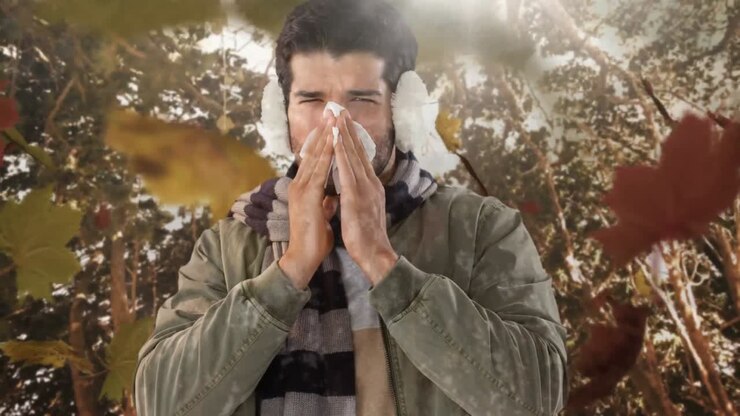 Foglie autunnali che cadono e uomo che starnutisce mentre soffre di allergia 4k