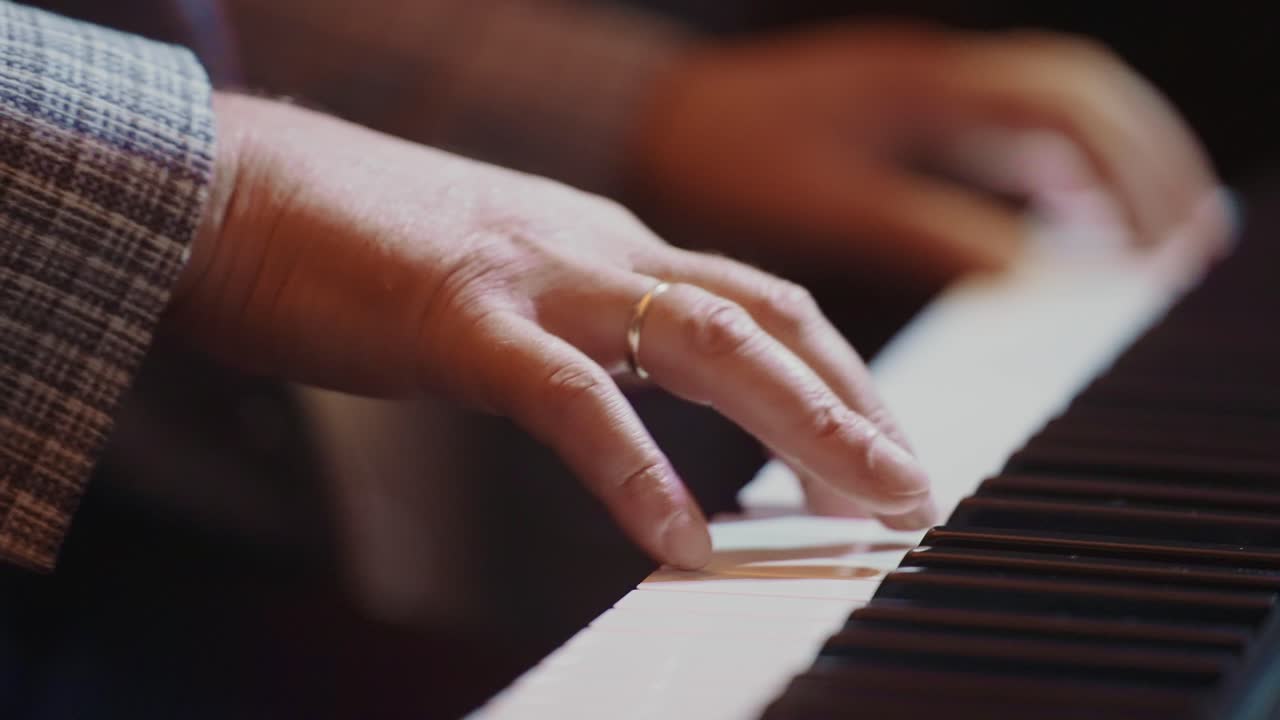Close-up of Musician's Hands Playing Piano Keys