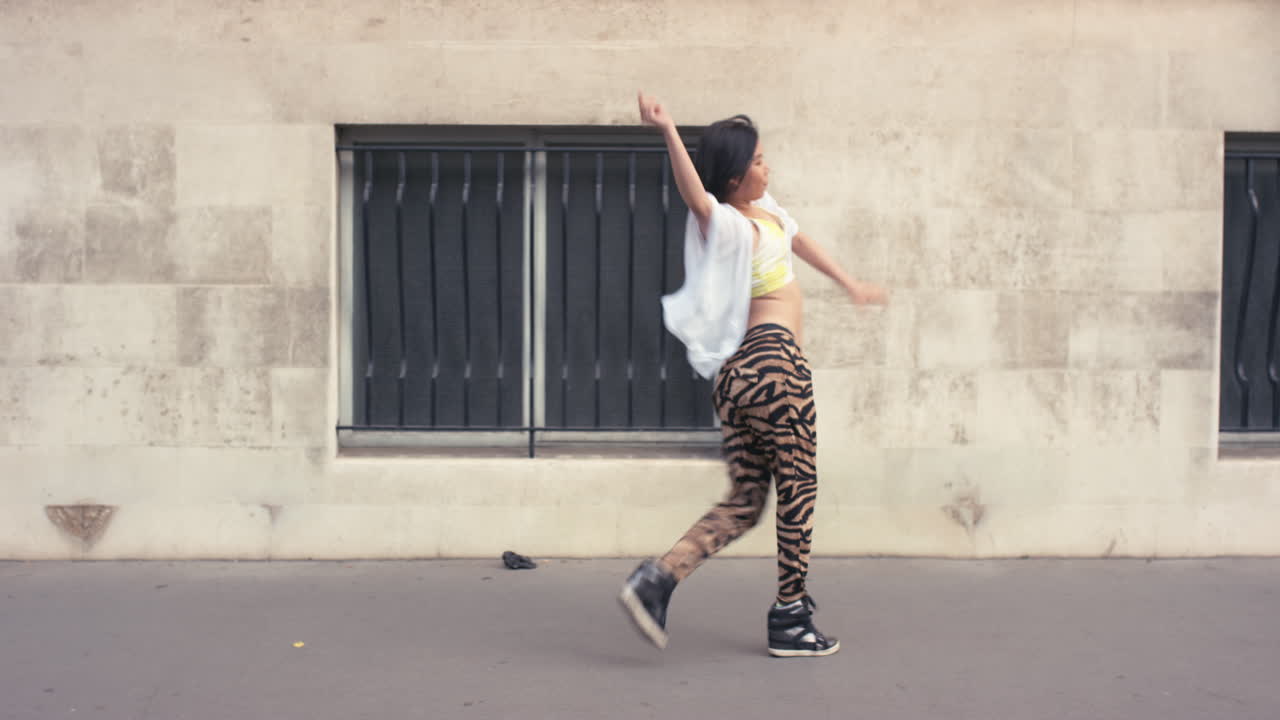 Donna asiatica ballerina di strada contemporanea e funky che balla freestyle in città.