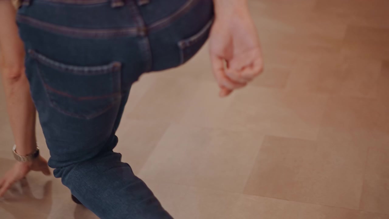 White student walking down hallway in jeans and socks, carrying rehearsal mood into corridor dance trainee exiting studio between classes, quiet reflective pace, focused posture, wooden floors