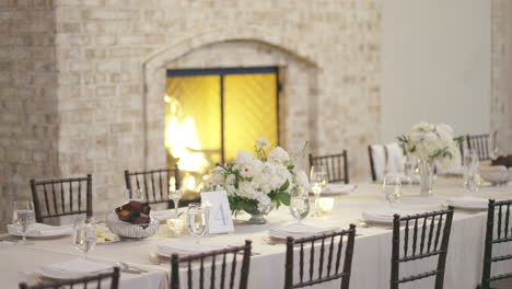 interior wedding venue dining tables prepared for guests by cozy fireplace