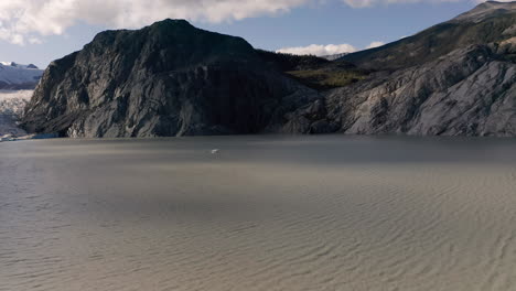una fotografía de un avión marítimo en un lago glaciar en las montañas de la columbia británica antes de despegar