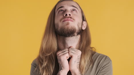 caucasian young man making a wish in front of the camera.