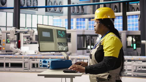 vertical video portrait of cheerful factory engineer typing on pc, monitoring production lines