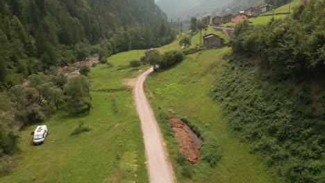 white van park near forested valley with flowing stream during sunset in northern italy