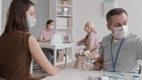 doctor injecting young woman