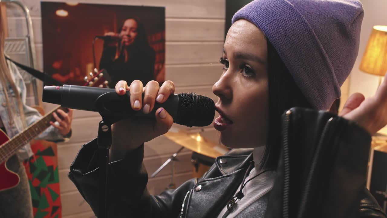 Attractive Young Woman Singing With Band In Studio