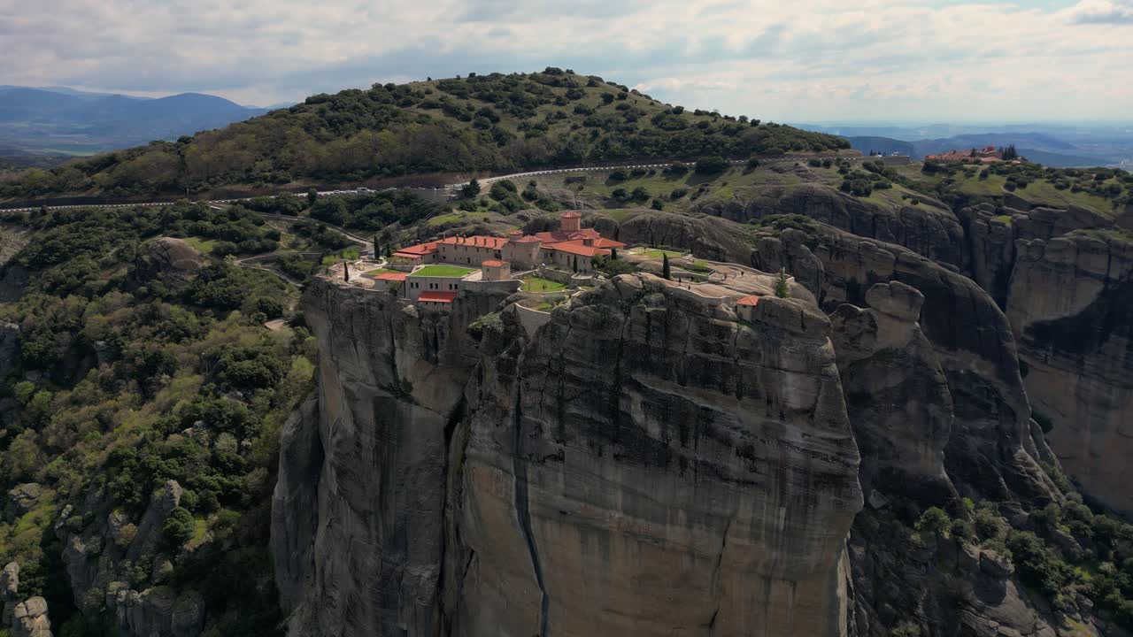 Sweeping drone establishing of Roussanou Monastery surrounded by sheer cliffs in Meteora