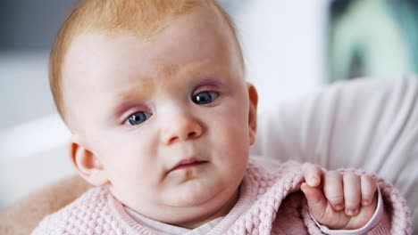 sweet red haired baby sitting in parent hands