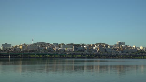 horizonte de seúl desde el paseo marítimo del parque del río han con la torre n de seúl y el distrito de yongsan sobre un cielo azul claro, tráfico en la autopista gangbyeon - espacio de copia