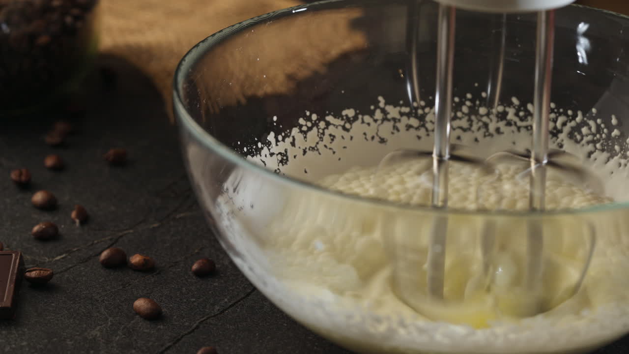 Preparazione del tiramisù in una ciotola con uno sbattitore elettrico. Primo piano.