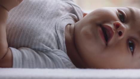 close up happy baby lying on changing table healthy little toddler looking playfully curious