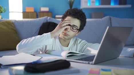 tired and sluggish male student is getting bored and taking a break while studying at home.