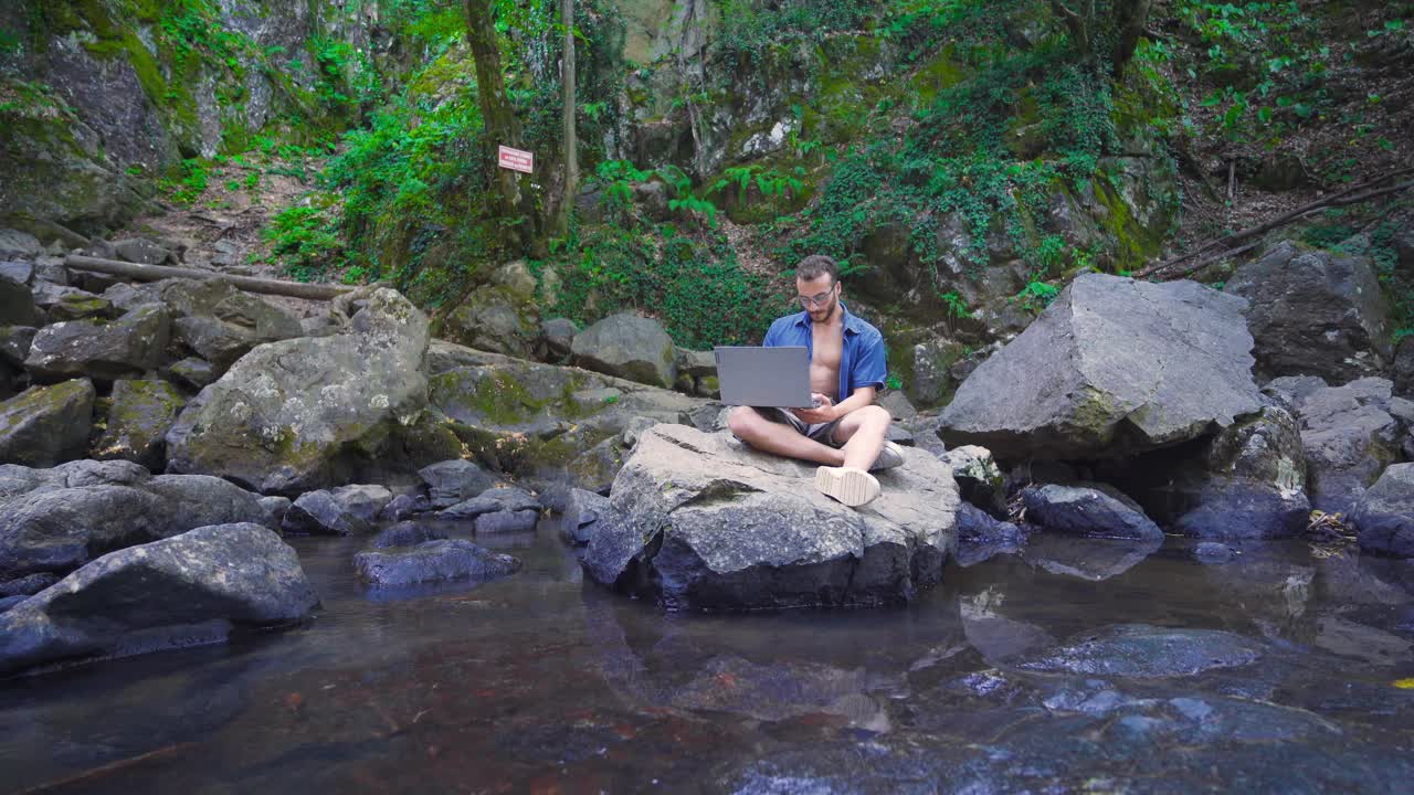 야외에서 노트북을 사용하는 남성.