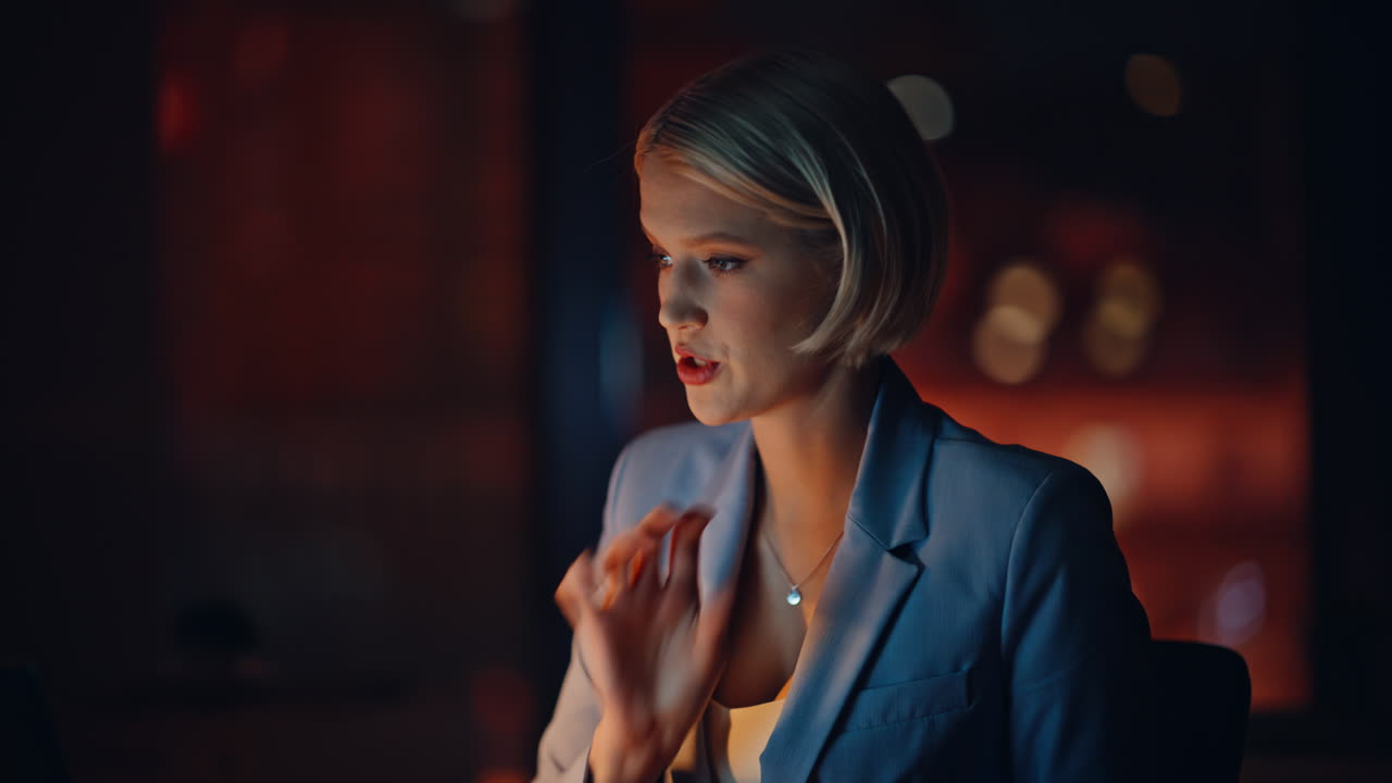 Skilful specialist explaining online dark office closeup. Smiling woman talking