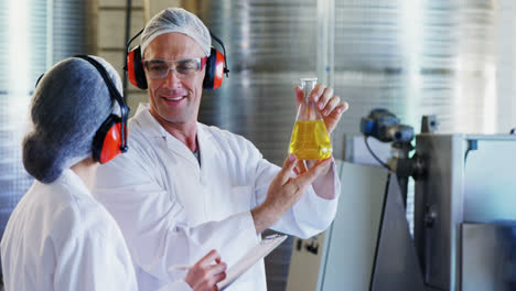 technicians examining olive oil