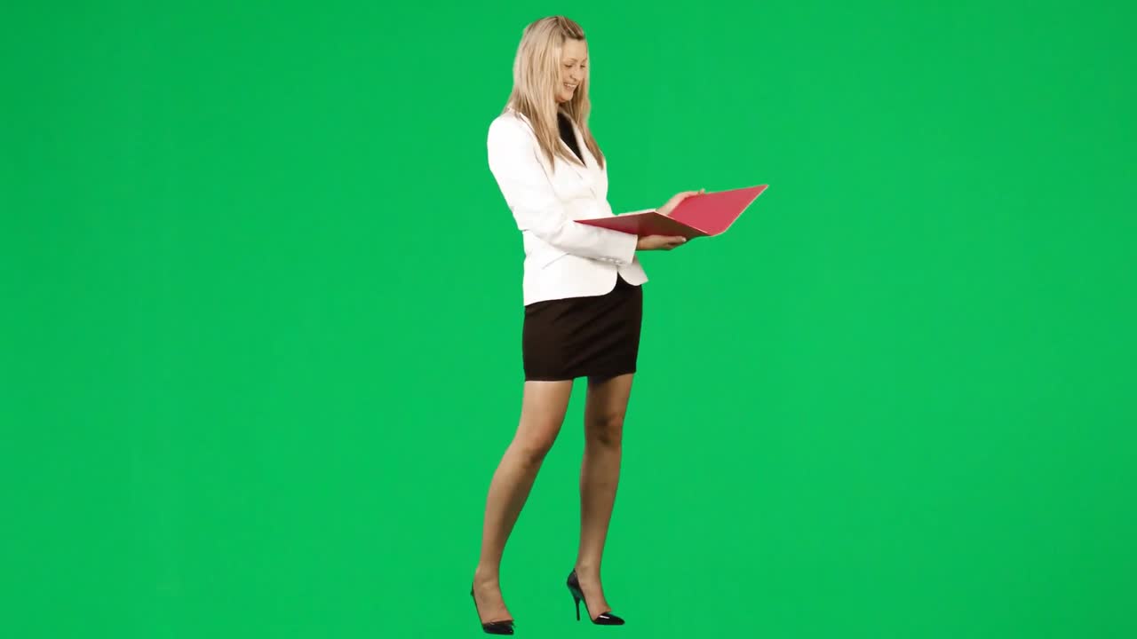 비즈니스 우먼이 녹색 스크린 영상에 대한 보고서를 읽고 있습니다.