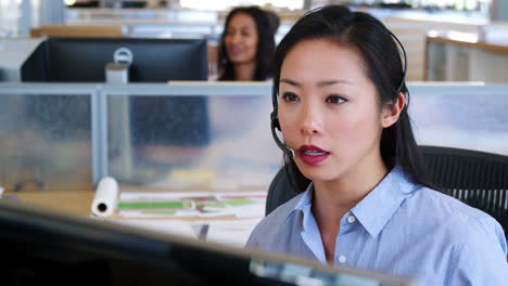 young asian woman working at a call centre, close up