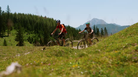 two people on e-bikes enjoying a mountain trail in summer