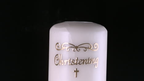 lit christening candle flickering and going out