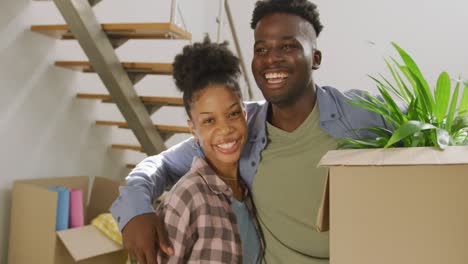 Video-of-happy-african-american-couple-embracing-after-moving-into-new-house
