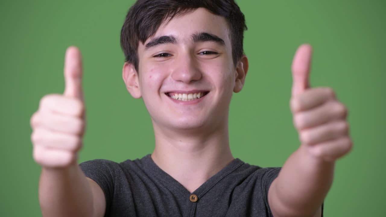 초록색 배경에 젊은 잘생긴 이란 십대 소년