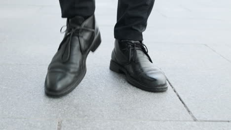 Businessman-in-black-shoes-going-for-job.-Man-legs-walking-on-city-road