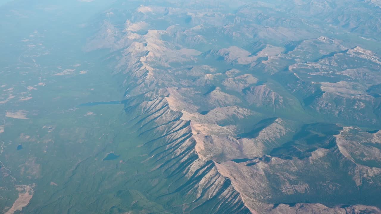Aerial drone footage of sprawling desert mountains casting long shadows under soft evening light