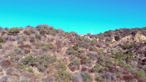 rising aerial over the hollywood hills reveals hikers near the hollywood sign and hillside mansions neighborhoods and homes